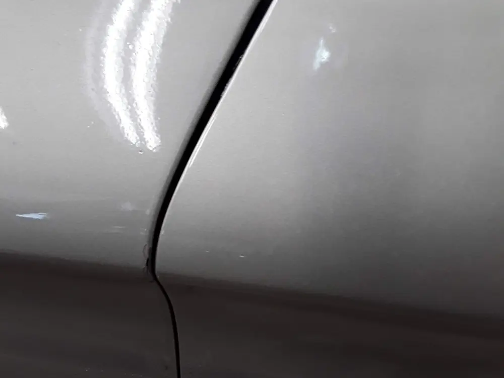 A door and front fender meeting at an uneven gap.