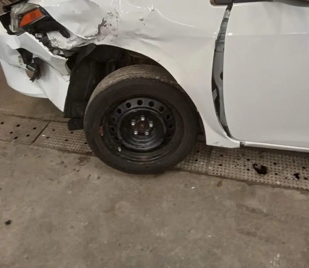 White sedan arriving with a crushed front corner and fender