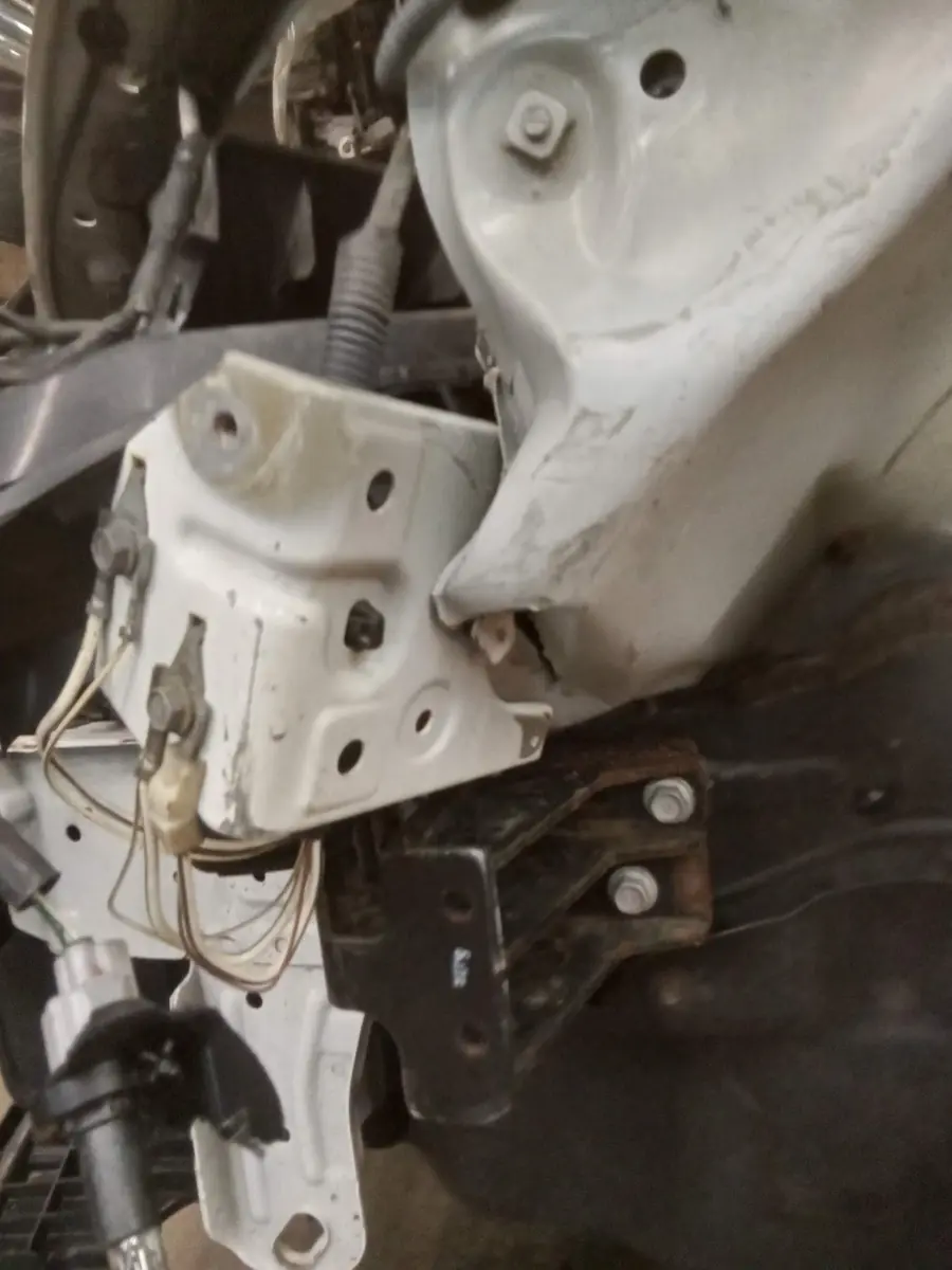 Close-up of bent front structure and brackets after disassembly