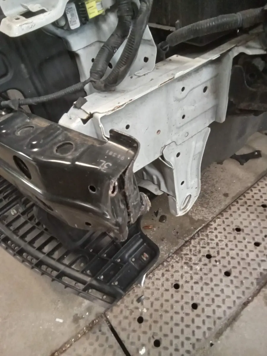 The same sedan with the bumper cover removed, showing a displaced reinforcement and front structure