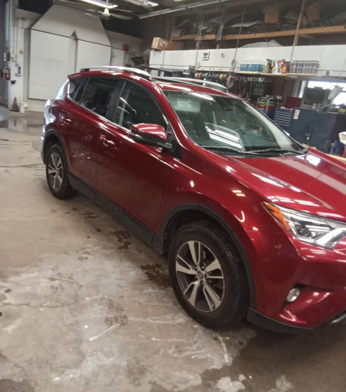 A red SUV in a repair bay inside the Collision Repair 1 Stop shop