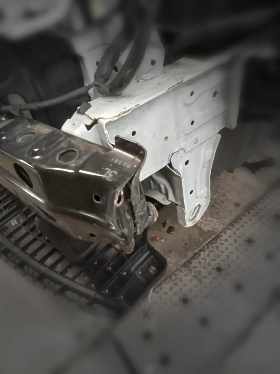 Sedan with bumper cover removed, exposing front reinforcement