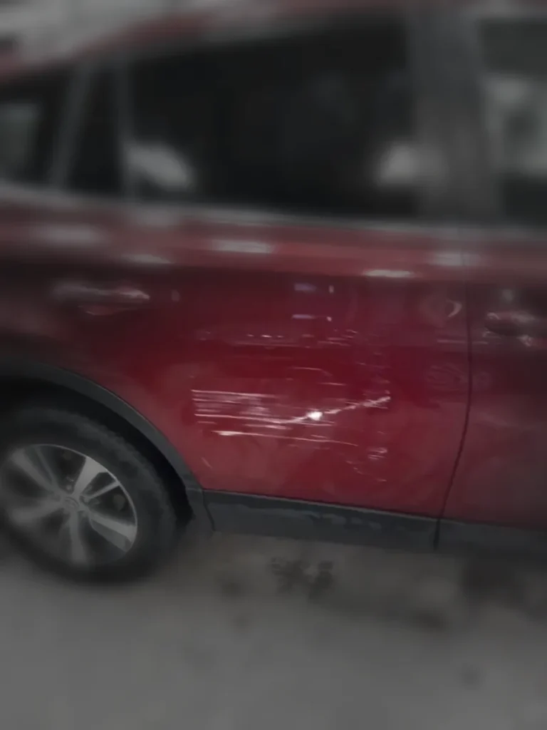 Scrape damage across a red rear door
